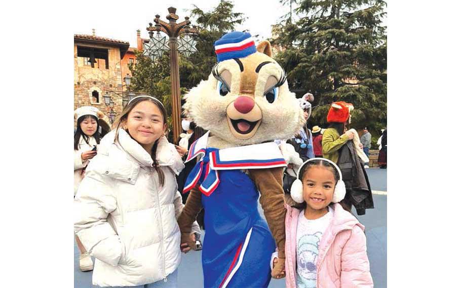 Addison and her sister pose for a photo with one of the Disney mascots at DisneySea.