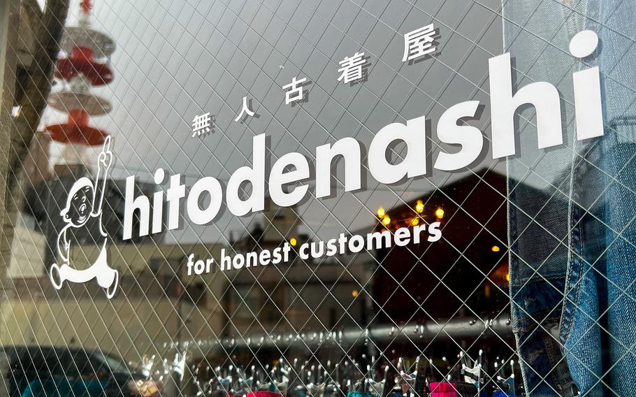 Clothes are visible through a store window, and the name of the store is written on the window.