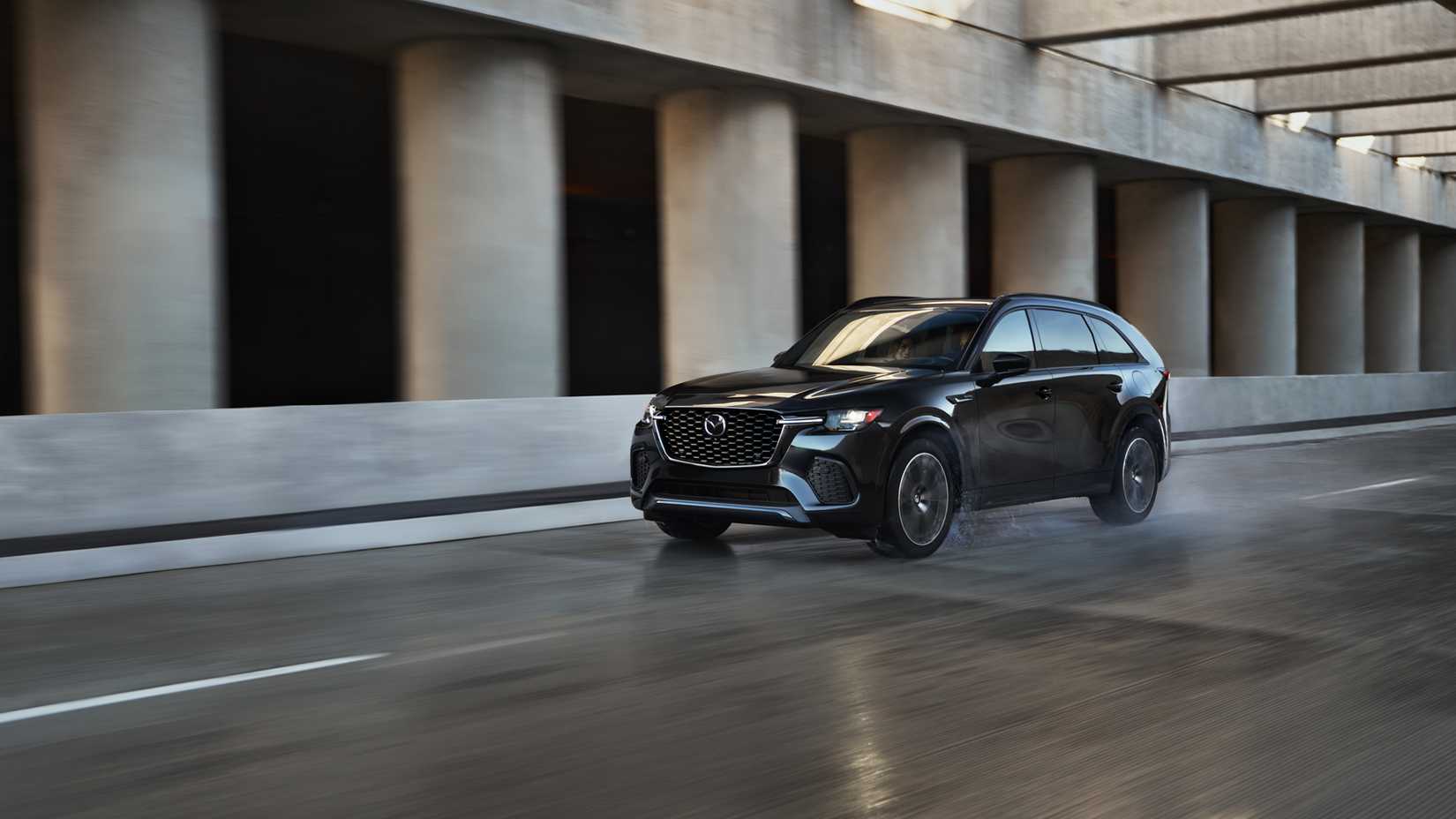 Front shot of a 2026 Mazda CX-70 driving on a wet road