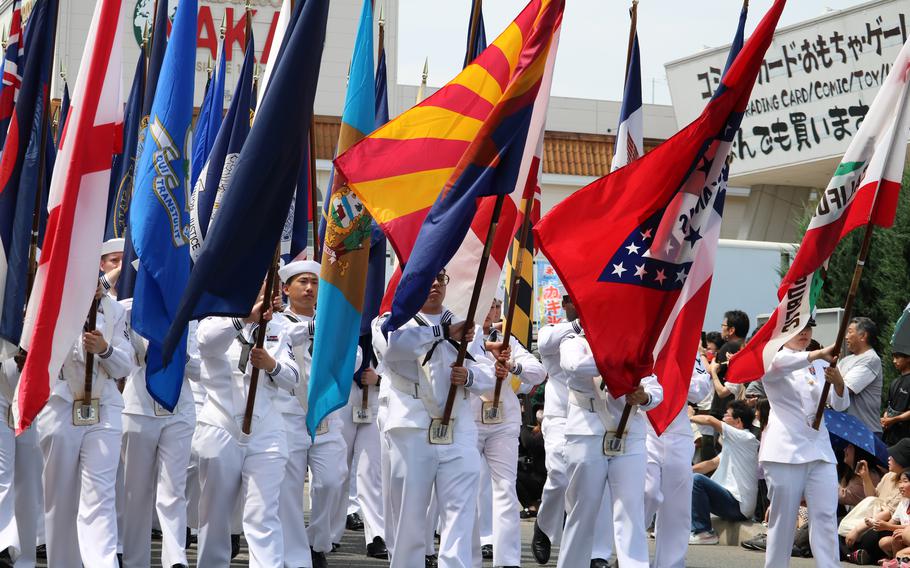 Sailors holding different state flags.