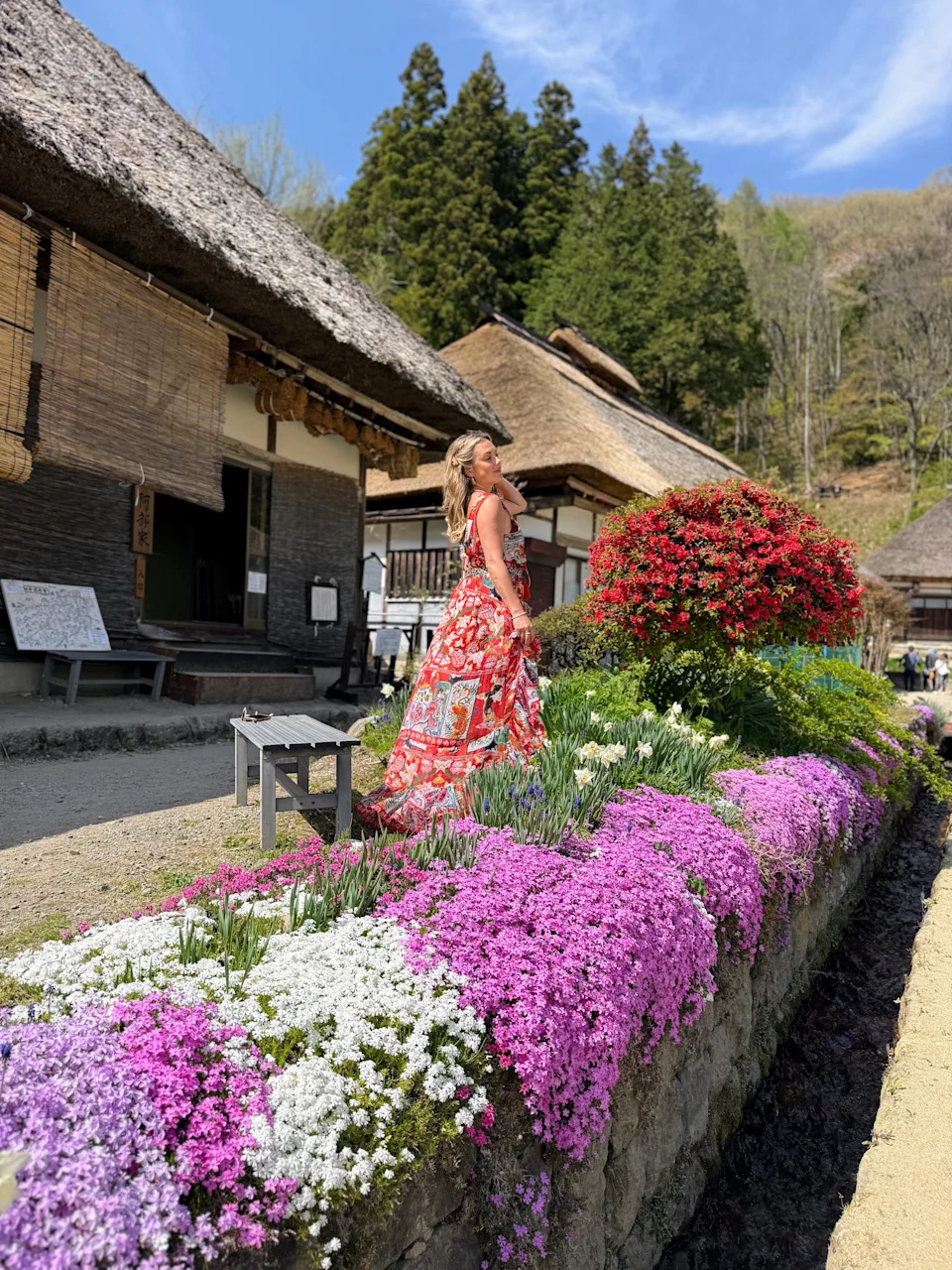 A woman strolling near blooming flowers in Ouchi Joku Old Town in Fukushima Japan