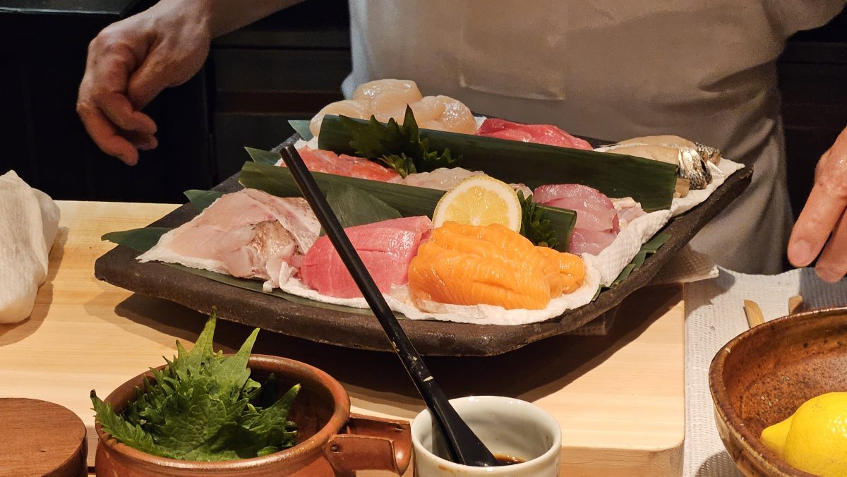 Nine types of fish are displayed on a ceramic platter.