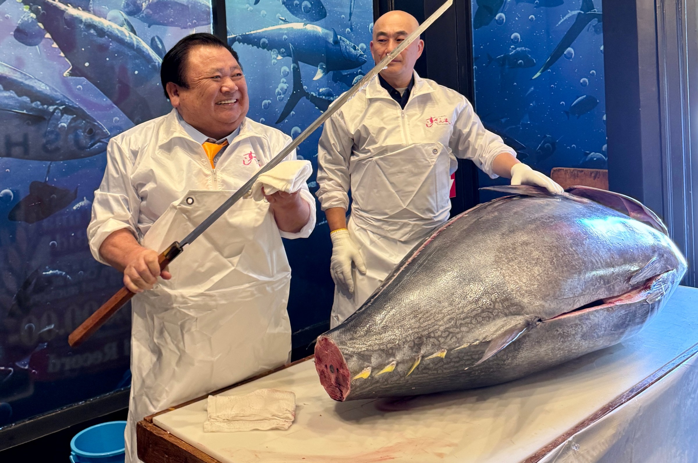 Kiyoshi Kimura holding a katana in front of a tuna Sushi Zanmai.