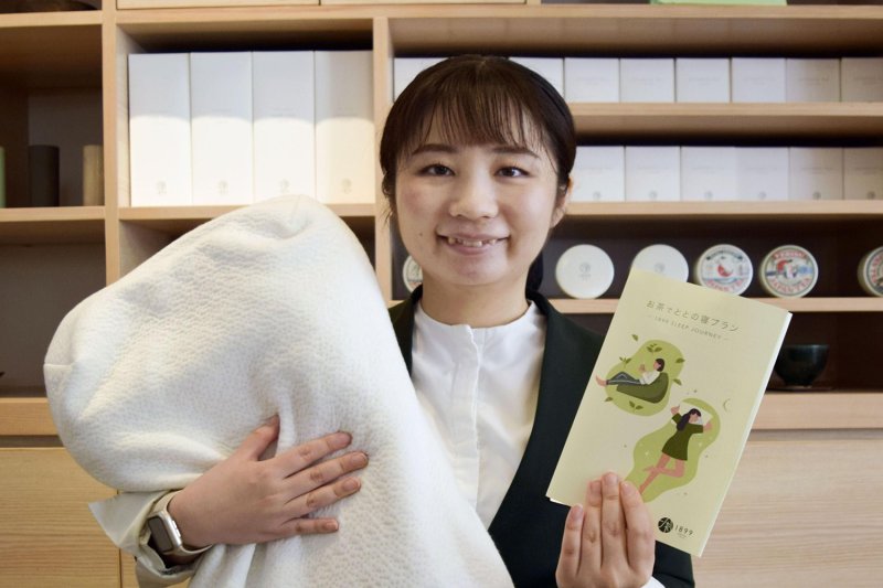 Hotel 1899 Tokyo's Yuiko Ogawa holds a leaflet and a high-performance pillow used for its "Totono-ne" sleep plan in Tokyo on July 21. (Photo: Kyodo)