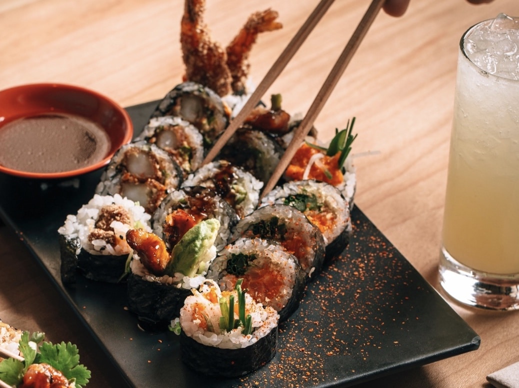 someone using chopsticks to pick up a tuna sushi roll from sushi san in chicago