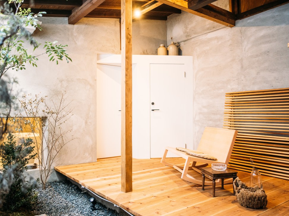 Wooden terrace at A Day in Khaki guesthouse with white doors, exposed wooden beams, and slotted wooden screens.