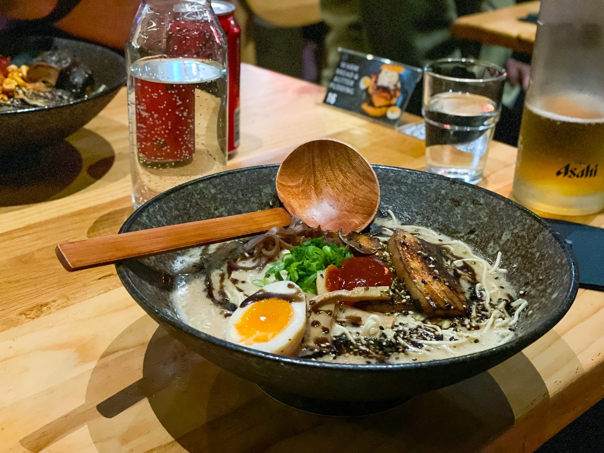 A bowl of ramen with wooden spoon.