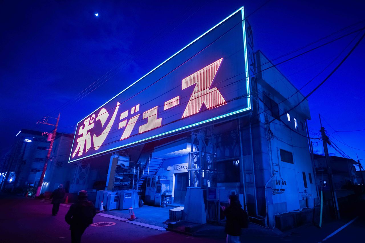 This huge neon sign advertising orange juice, erected in 1975, is visible on the left from the monorail leaving the airport. (© Hatsuzawa Ari)
