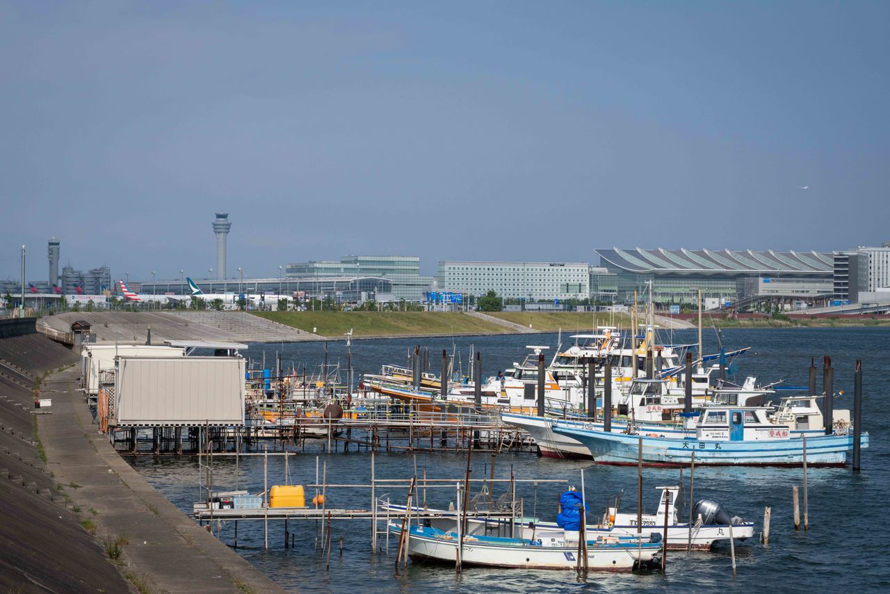 A small fishing port with Haneda Airport’s international terminal visible in the background. (© Hatsuzawa Ari)