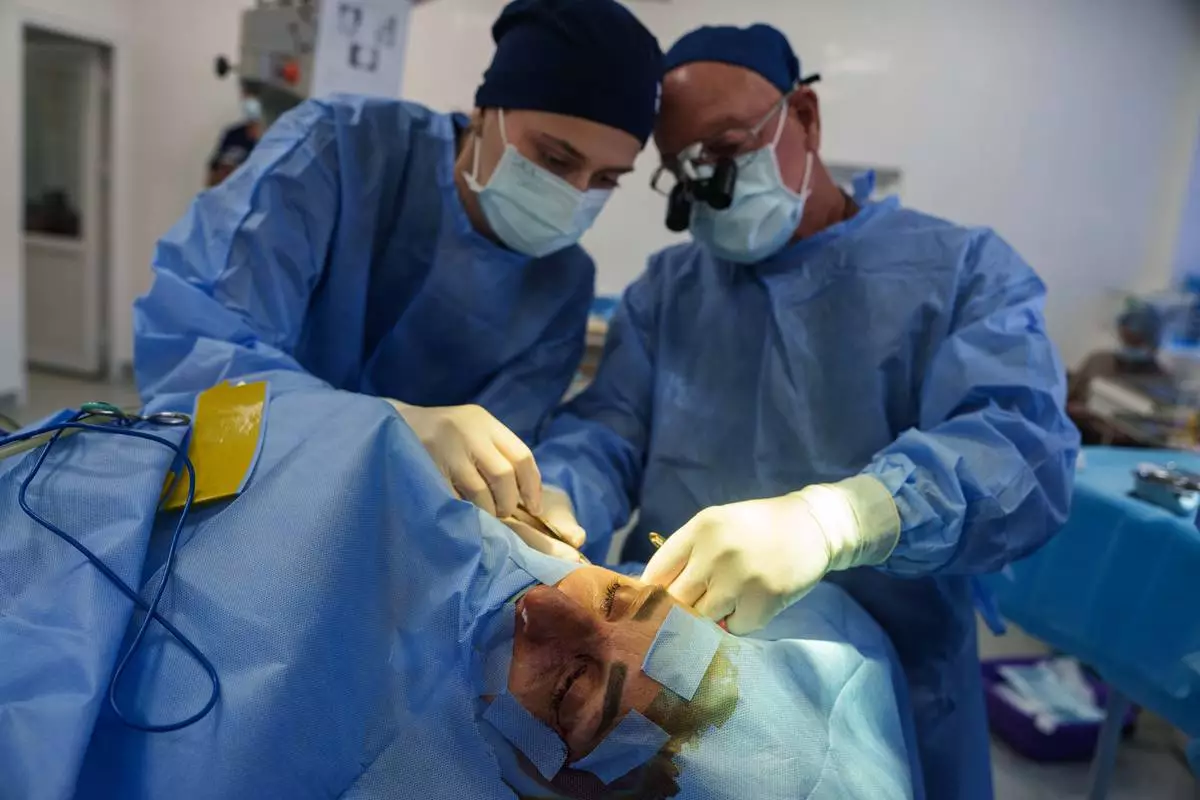 Stuart Seiff, a U.S. oculoplastic surgeon, right, and a Ukrainian colleague perform a surgical operation on the eye of a wounded soldier at a regional hospital in Kyiv, Ukraine, Tuesday, Sept. 29, 2026. (AP Photo/Evgeniy Maloletka)