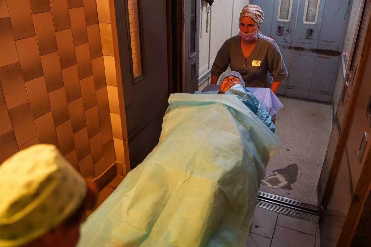 Nurses transport wounded soldier Mykola Kasiuk, into a surgical unit at a hospital in Kyiv, Ukraine, Monday, Sept. 28, 2026. (AP Photo/Evgeniy Maloletka)